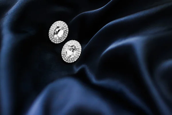 深蓝色丝绸背景的豪华钻石耳环，节日 gl — 图库照片