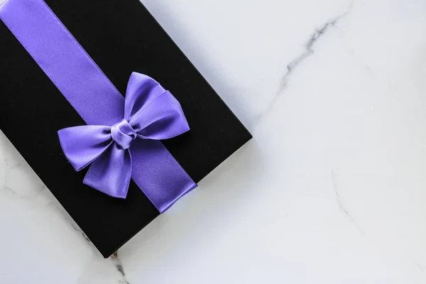 Luxury holiday gifts with lavender silk ribbon and bow on marble — Stock Photo, Image