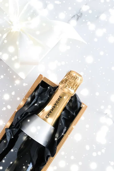 Bouteille de champagne de Noël et boîte cadeau et neige brillante — Photo