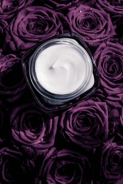 Creme de cara hidratante de pele em rosas roxas flores, pele de luxo — Fotografia de Stock