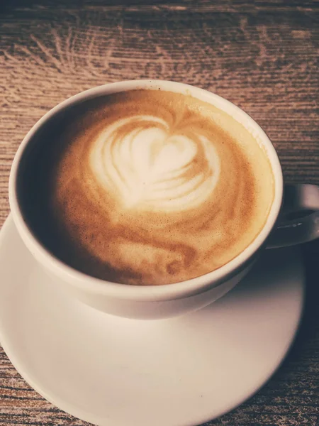 Filiżanka gorącej cappuccino w kafeterii, kawa na drewnianym stole i — Zdjęcie stockowe