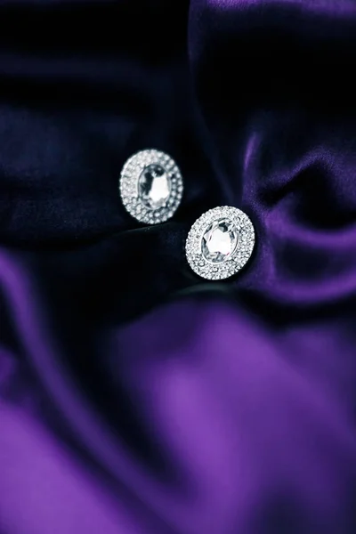 Pendientes de diamantes de lujo en tela de seda violeta oscura, glam navideño —  Fotos de Stock