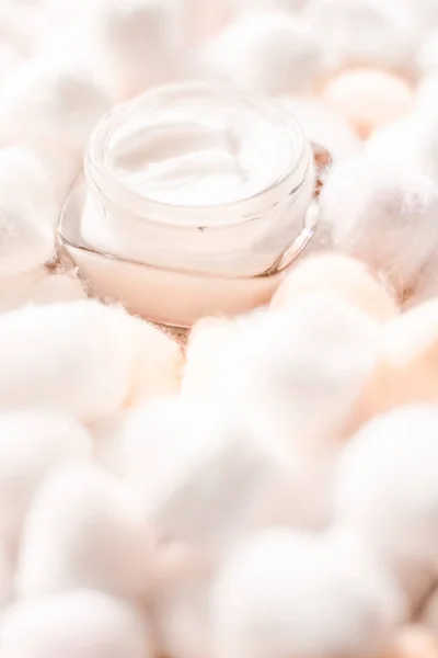 Luxury face cream for sensitive skin and orange cotton balls on