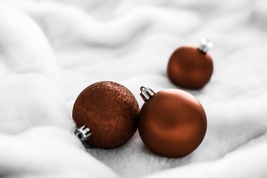 Beyaz kabarık kürk zemin üzerinde Çikolata kahverengi Noel baubles, 
