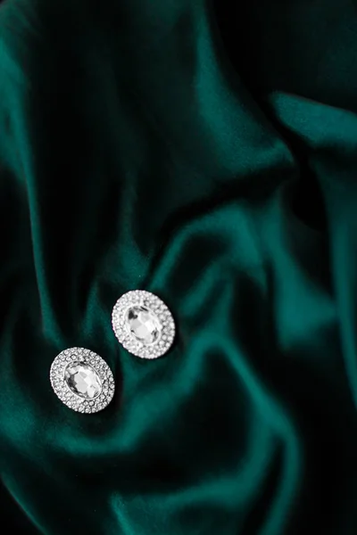 Pendientes de diamantes de lujo en seda verde esmeralda oscura, glamour navideño —  Fotos de Stock