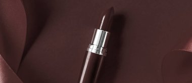 Lüks ruj ve çikolata bayramı arka planında ipek kurdele.,