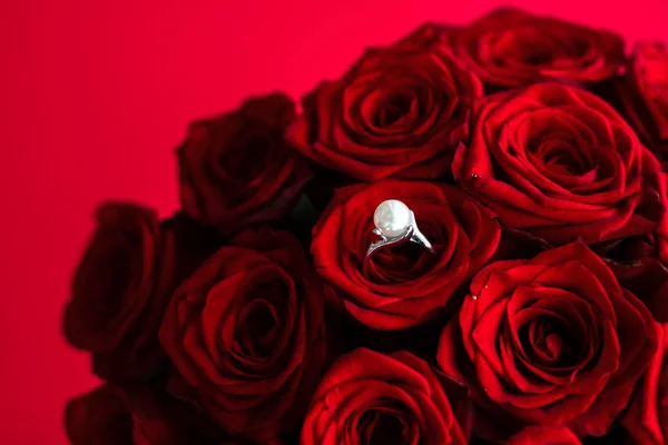 Wunderschöner Perlenring aus Weißgold und Strauß roter Rosen, Luxus — Stockfoto