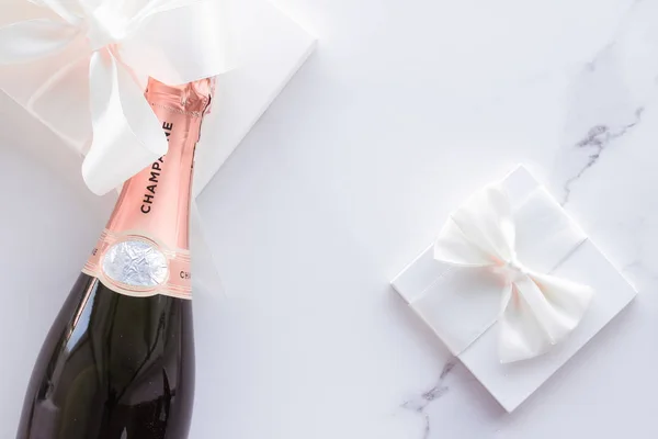 Champagnerflasche und Geschenkbox auf Marmor, Neujahr, Weihnachten, v — Stockfoto