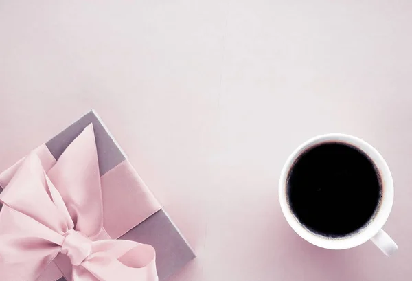 Caixa de presente de luxo e xícara de café no fundo rosa blush, flatlay — Fotografia de Stock