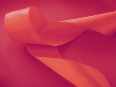 Gül arka planında soyut kıvrımlı ipek kurdele, özel lüks. 