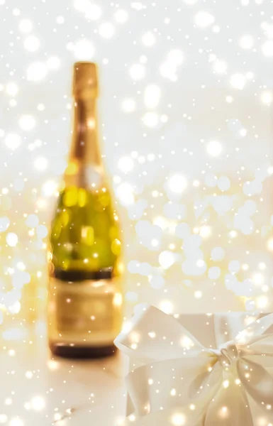 New Years Eve holiday champagne bottle and a gift box and shiny — Stock Photo, Image