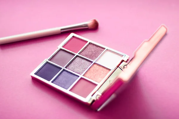 Paleta powiek i pędzel do makijażu na różowym tle, golenie oczu — Zdjęcie stockowe