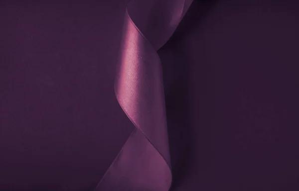 Abstract curly silk ribbon on purple background, exclusive luxur