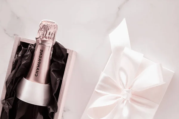 Пляшка шампанського і коробка з подарунками на мармурі, Новий рік, Різдво, В. — стокове фото