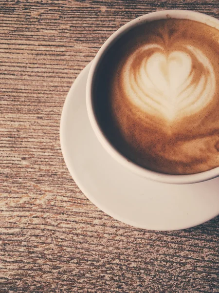 Xícara de cappuccino quente em uma cafetaria, café em uma mesa de madeira i — Fotografia de Stock