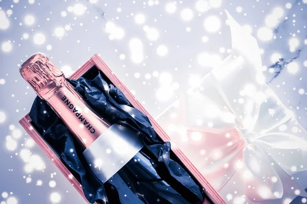 Бутылка шампанского и подарочная коробка на голубые праздничные блестки, Новый год — стоковое фото
