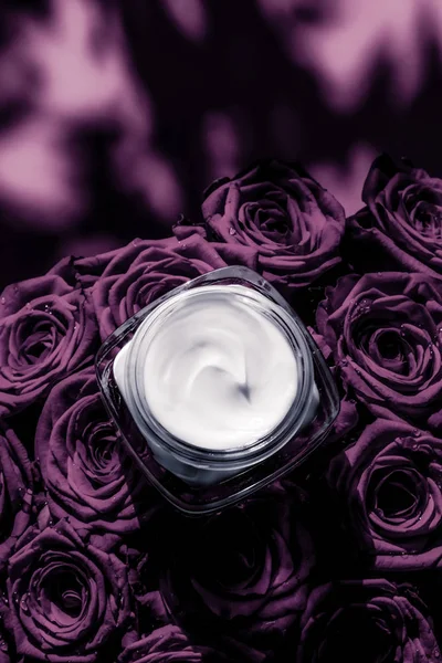 Увлажняющий крем для лица на фиолетовых цветах роз, роскошная кожа — стоковое фото