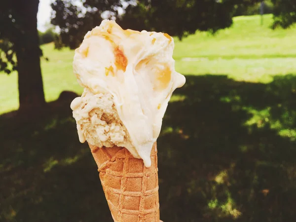 Ice cream cone melting outdoors in summer, sweet dessert food on — Stock Photo, Image