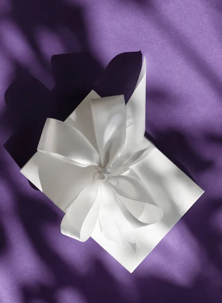 Πολυτελές λευκό κουτί δώρων με μεταξωτή κορδέλα και τόξο σε βιολετί — Φωτογραφία Αρχείου