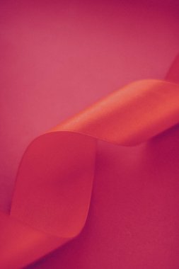 Gül arka planında soyut kıvrımlı ipek kurdele, özel lüks. 