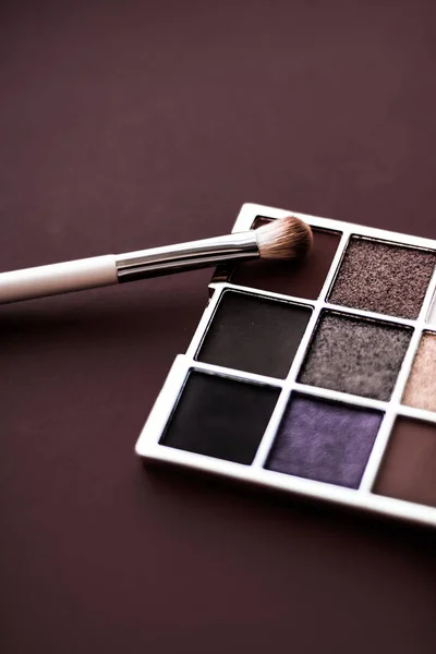 Eyeshadow palette and make-up brush on chocolate background, eye — Stock Photo, Image