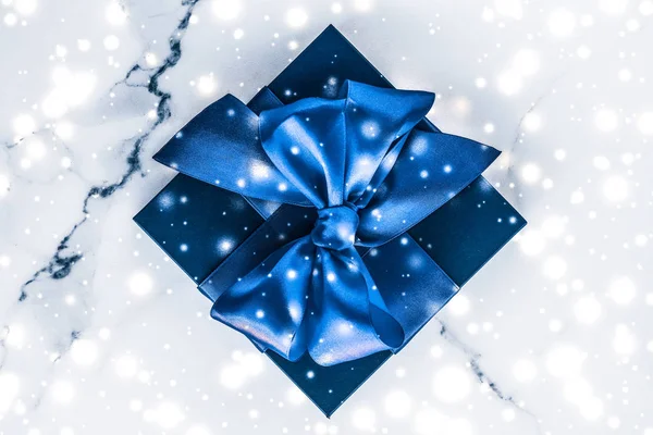 Caixa de presente de férias de inverno com arco de seda azul, brilho de neve em marb — Fotografia de Stock