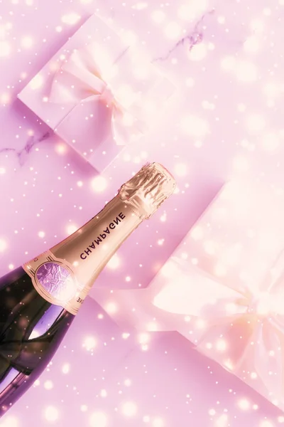 Bouteille de champagne et boîte cadeau sur paillettes de vacances roses, Nouvel An — Photo