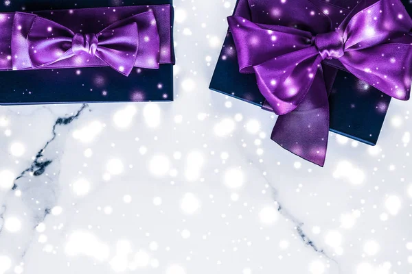 Winter holiday gift box with purple silk bow, snow glitter on ma — Stock Photo, Image