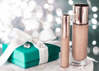 Tatil makyaj malzemesi, kapatıcı ve yeşil hediye kutusu.