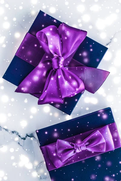 Winter holiday gift box with purple silk bow, snow glitter on ma — Stock Photo, Image