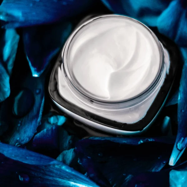 Crema hidratante facial de lujo para la piel facial en bac de flor azul —  Fotos de Stock