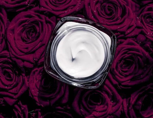 Crema facial hidratante para la piel y flores moradas oscuras, piel de lujo — Foto de Stock