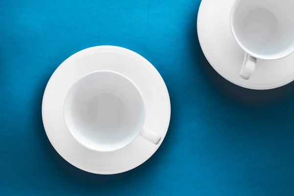 White tableware crockery set, empty cup on blue flatlay backgrou