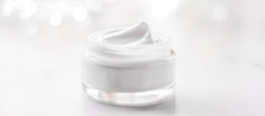 Facial cream moisturizer jar on holiday glitter background, mois clipart