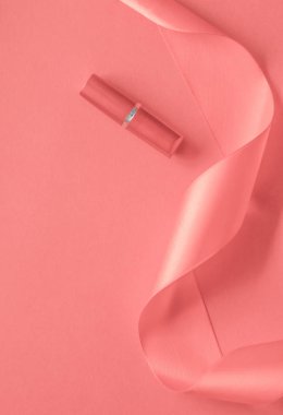 Mercan bayramı arka planında lüks ruj ve ipek kurdele, mak