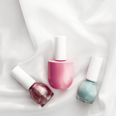 İpek arka planda oje şişeleri, Fransız manikür ürünleri.