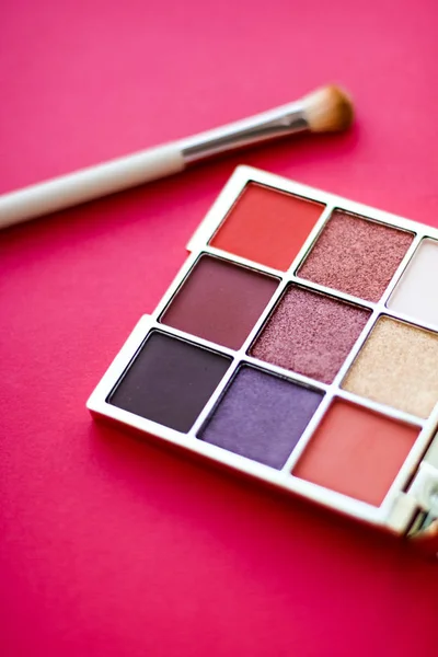 Paleta stínů očí a make-up štětec na červeném pozadí, odstín očí — Stock fotografie