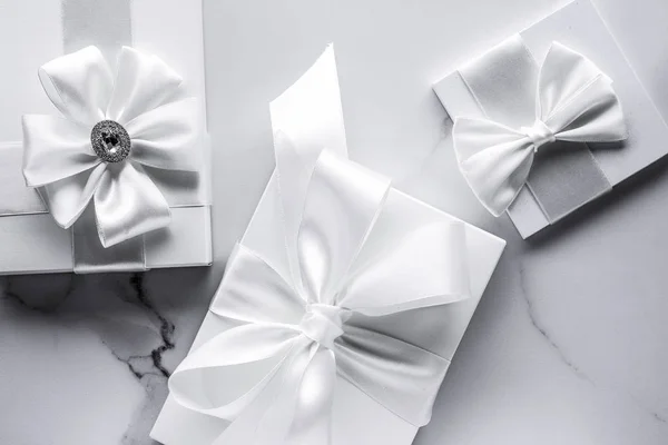 大理石のバックグロにシルクの弓とリボンを持つ豪華な結婚式の贈り物 — ストック写真