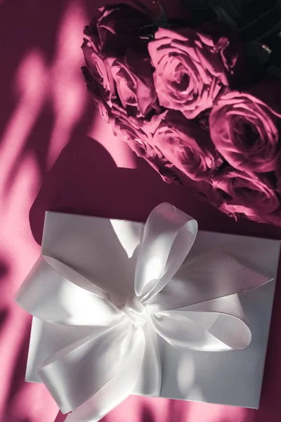 Luxo feriado caixa de presente de seda e buquê de rosas no backgr rosa — Fotografia de Stock