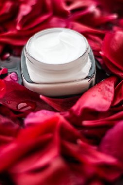 Kırmızı çiçek yaprakları ve WA Hassas Cilt Bakımı nemlendirici krem