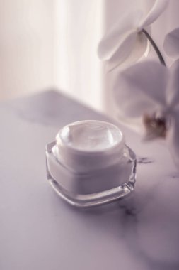 Face cream moisturizer jar and orchid flower, moisturizing skin  clipart