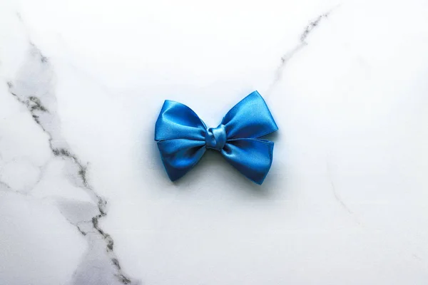 Blue silk ribbon and bow on luxury marble background, holiday fl — Stock Photo, Image