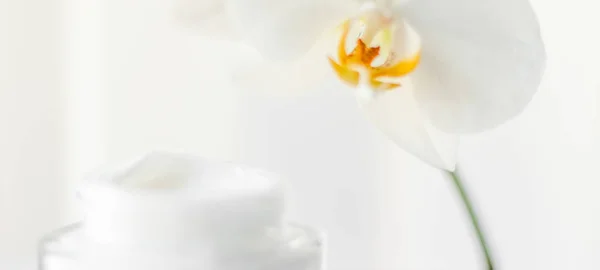 Arc krém hidratáló üveg és orchidea virág, hidratáló bőr — Stock Fotó