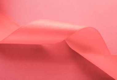 Mercan zemin üzerinde soyut kıvrımlı ipek kurdele, özel lüks.