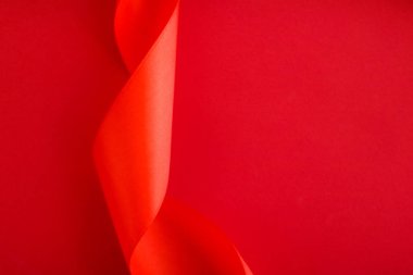 Kırmızı arka planda soyut kıvrımlı ipek kurdele, özel lüks b