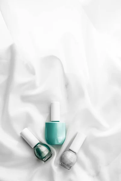 Nagellak flessen op zijde achtergrond, franse manicure producten — Stockfoto