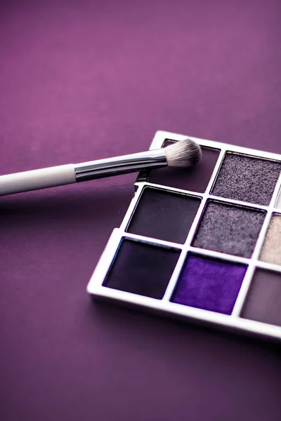 Палітра тіней та пензлик для макіяжу на фіолетовому фоні, ш — стокове фото