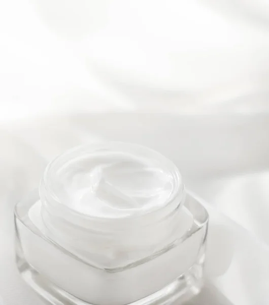 Crema facial hidratante tarro sobre fondo de seda, hidratante piel — Foto de Stock