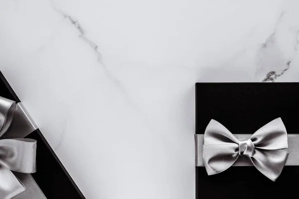 Regalos de lujo con cinta de seda plateada y lazo en mármol b — Foto de Stock