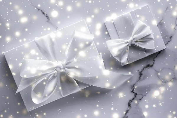 Luxusní prázdninové dárky s bílým hedvábným lukem a stuhami na mramoru b — Stock fotografie